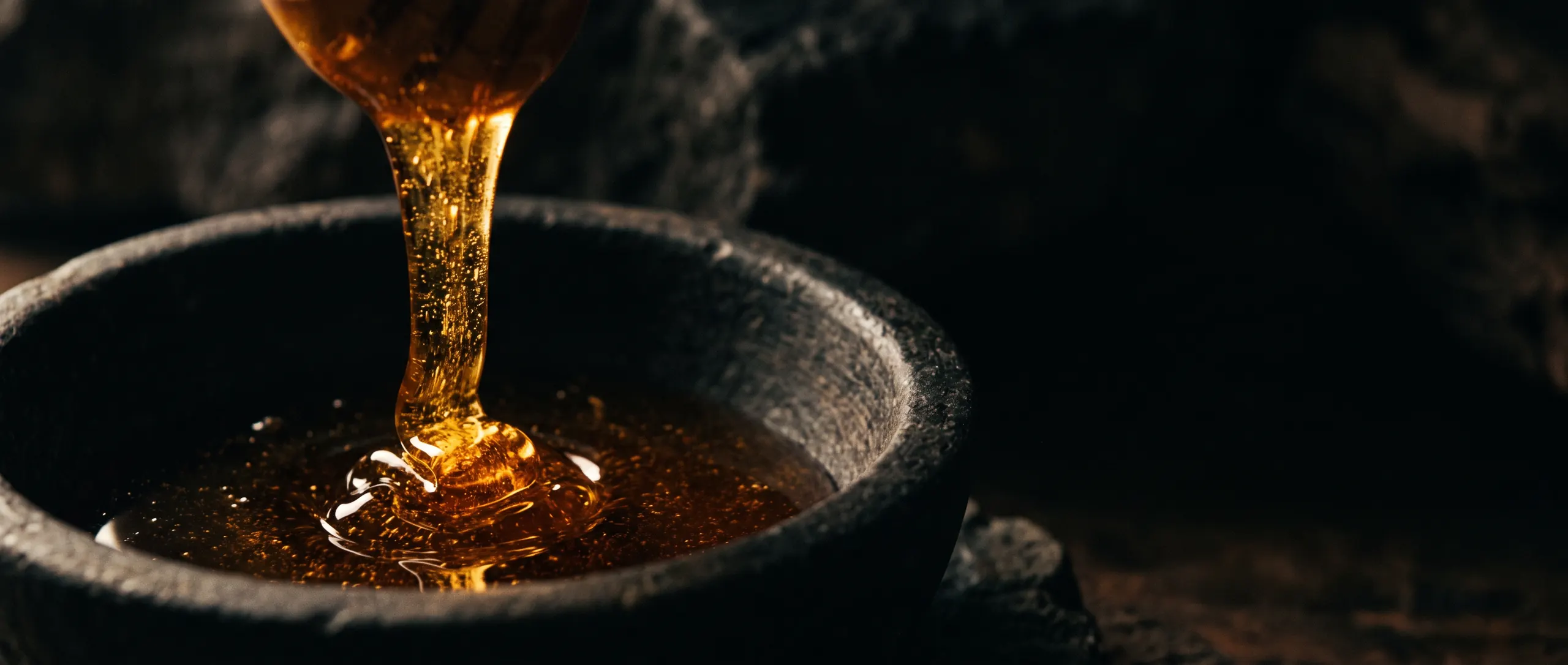 Dark amber honey falling in a slow ribbon